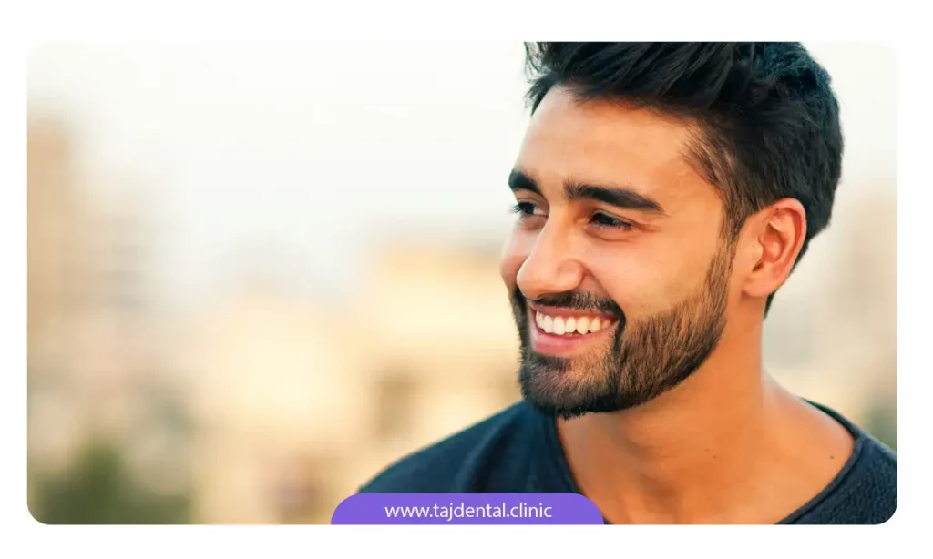 مرد جوانی که بعد از ارتودنسی دندان های مرتبی دارد و در حال لبخند زدن است