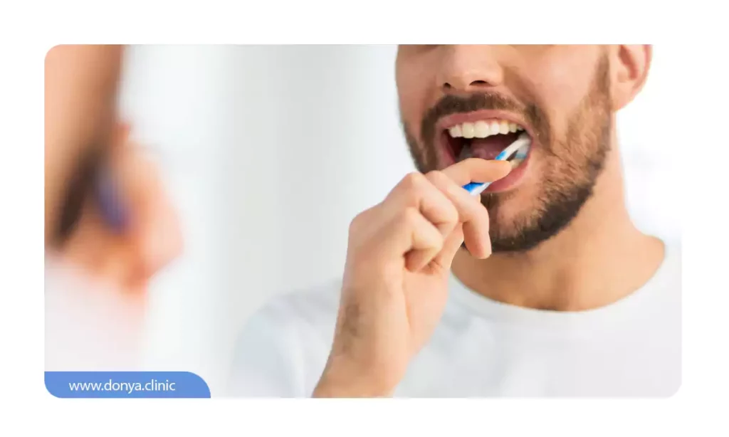 مردی که بعد از جرمگیری دندان مشغول مسواک زدن است